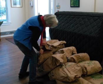 Pantry volunteer Barbara Fritz opens one of many bags of potatoes. JANE CARPENTER/Boothbay Register