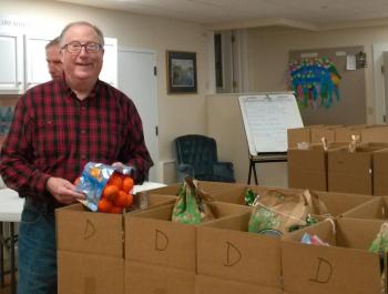 Pantry co-president Fleet Davies helps put clementines into boxes. JANE CARPENTER/Boothbay Register