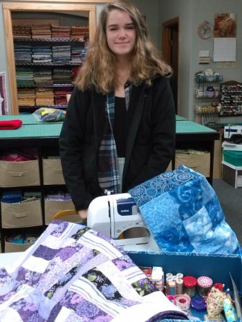 Sophia Gudroe shows her sewing machine and supplies and her recently completed quilt. JANE CARPENTER/Boothbay Register