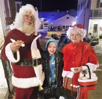 Suzie Edwards squeezes in between Santa and Mrs. Claus at the sidewalk barbecue. STEVE EDWARDS/Boothbay Register