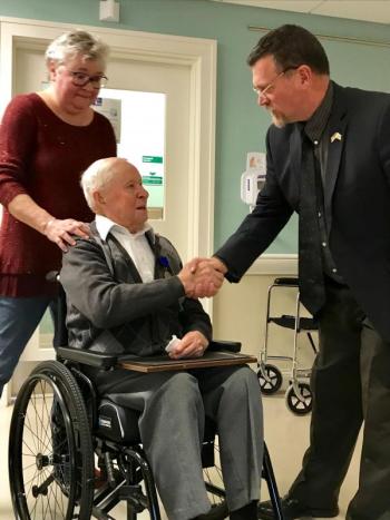 Acting Director, David Richmond from the Maine Bureau of Veterans’ Services congratulates Corporal West while his daughter, Debbie, looks on at the Zimmerli Pavilion at St. Andrews Village. Courtesy of Sarah Sherman