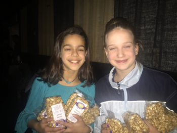 Sophia Scott, left, and Lily Nein handing out bags of Coastal Maine Popcorn’s gourmet Maine maple popcorn