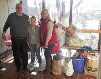 Suzie delivering clothes for kids from The Clothing Closet collection on Jan. 2 to Boothbay Region Elementary School. Accepting the donations are BRES Principal Mark Tess and Assistant Principal Trish Campbell. STEVE EDWARDS/Boothbay Register
