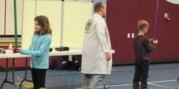 These two elementary school students assist “Catalyst Corey” during a kinetic energy demonstration during a Jan. 15 Mad Science of Maine performance in Edgecomb. BILL PEARSON/Boothbay Register