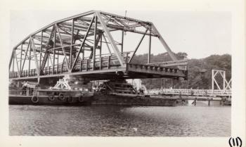A barge brings in the bridge. Courtesy of MDOT historic bridge archives