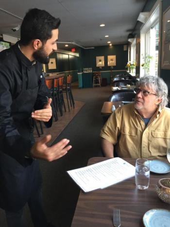 Sahin explains the menu to Doug Hayner. KELLIE BIGOS/Boothbay Register