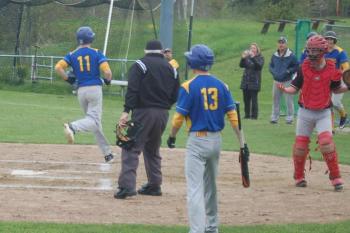 Senior Will LaBrecque holds a bat as classmate Brett Hollowell scores. ART MAYERS/Boothbay Register