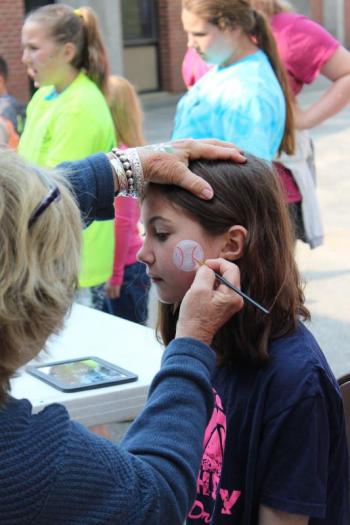 Natalie Flagg sits still as a baseball is drawn on her face. The face painting station was the most popular station during the festivities. PAGE BROWN/Boothbay Register