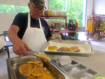 Edgecomb Fire Department member Bill Witzell updates the pancake tray at the auxiliary’s June 29 breakfast at the station. SUSAN JOHNS/Wiscasset Newspaper
