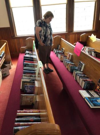A customer looks over the selection of mysteries and thrillers. CRAIG LANCASTER/Boothbay Register Southport, Southport Country Fair, Southport Town Hall, Southport United Methodist Church