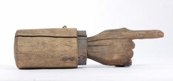 A trade sign in the shape of a pointing hand, made from carved and painted wood, 6” X 21,”