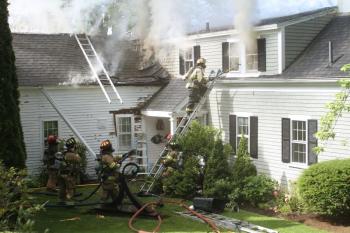 Firefighters work to gain access to the second story of the house. STEVE EDWARDS/Boothbay Register