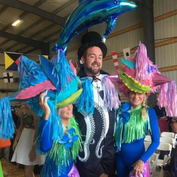 Emcee Michael Maxim looks quite happy with a Bielli sister – Andy and Adele – on each arm after last year’s show. File photo