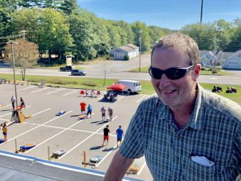 Roof with a view: Ames True Value co-owner Wayne Averill pauses for a photo as entrants warm up below; beyond the lot, Route 1. SUSAN JOHNS/Wiscasset Newspaper