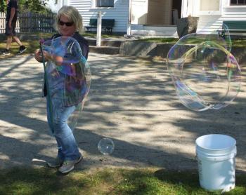 Boothbay Railway Village employee Karen Aumick shows visitors how to blow huge bubbles. BILL PEARSON/Boothbay Register
