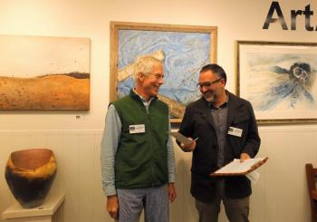 A surprised Andre Benoit accepts the Best In Show prize from juror Roy Germon. LISA KRISTOFF/Boothbay Register Andre Benoit and juror Roy Germon ARTinME 2019