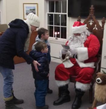 With a little help from their mom, Liam and Mason Wililams talk with Santa. JANE CARPENTER/Boothbay Register