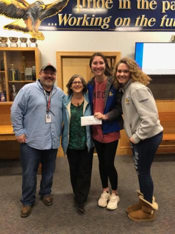 Glory Blethen hands a $650 check to Mary Hanley of New Hope for Women representing the money raised during the recent “wear purple” day. At left is BRHS athletic director Allan Crocker and at right is fellow BRHS girls basketball player Jaelyn Crocker. Courtesy photo