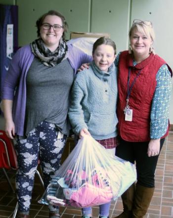 Suzie Edwards, center, delivers the boat load of clothing and cash, donated Dec. 29 at the Fill the Boat With Love event, to Boothbay Region Elementary School for BRES and high school students Jan. 2. Accepting them are guidance counselor Sarah Gordon, left, and Vice Principal Tricia Campbell. STEVE EDWARDS/Boothbay Register