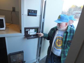 Ed Harmon checks out the mobile shelter’s electrical panel he and two other Boothbay region veterans developed in hopes of solving the state’s homeless veterans’ problem. BILL PEARSON/Boothbay Register