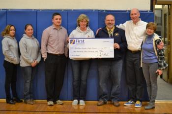 Boothbay Harbor branch manager Brenda Blackman and Boothbay Region High School athletic director Allan Crocker hold a mock check for $2,300, the First Hoop donation to BRHS from the First National Bank. Pictured from left are First National Bank employees Evelin Carrasco and Jolleen Marshall, BRHS boys basketball junior varsity coach Dan Hallinan, Blackman, Crocker, BRHS girls basketball varsity coach Brian Blethen and Susan Norton, executive vice president/chief administrative officer of First National Bank. KEVIN BURNHAM/Boothbay Register