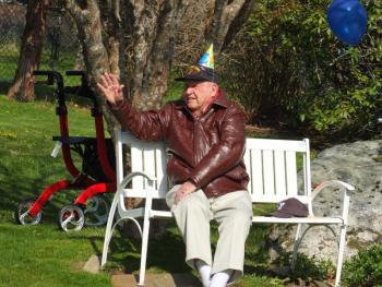 John Druce of Boothbay Harbor waves to a parade of well-wishers who wished him a Happy Birthday May 15 as he sat and watched them. BILL PEARSON/Boothbay Register