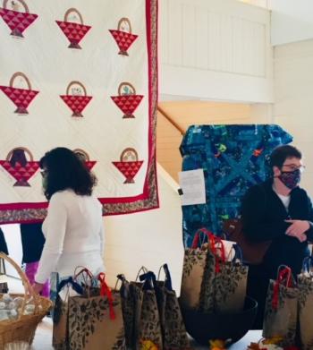 Elaine Gabrielli admires the "Friendship Basket" quilt hanging in the Old Town Hall as part of a display for the St. Andrews Auxiliary meeting. Melanie Groneng pictured on the right. Courtesy of Laura Zajdel