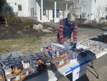 Food Pantry volunteer Jane Lunt stocks a table with canned beans. KEVIN BURNHAM/Boothbay Register