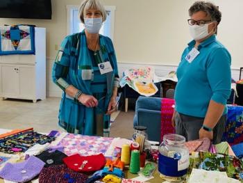 Auxiliary Members Nancy Conley (left) and Kevin Bowler cjeck out the Thrift Shop Fabrics display. Courtesy of St. Andrews Auxiliary