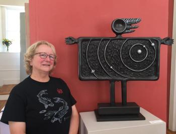 Clara Cohan and her cosmic sculpture, “Arms Around It.” The piece is one of 50 in Maine Art Gallery’s current show. LISA KRISTOFF/Boothbay Register Clara Cohan
