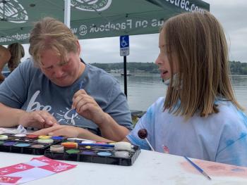 Kristy Lincoln paints the hand of Clover Apezynski, 9, at Schoonerfest Aug. 21. SUSAN JOHNS/Wiscasset Newspaper