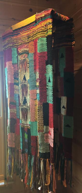 Ceremonial Dress - 96” - H, 36” - W. 14” - D. This stunning example of fiber art by Priscilla Alden is woven of wool and silk, accented with pheasant feathers and brass bells. Priscilla May Alden