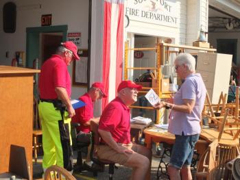 Southport fireman Smith Climo assists a customer at the annual fundraiser. BILL PEARSON/Boothbay Register