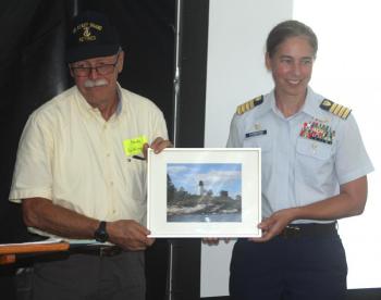 USCG Capt. Amy Florentino presents a framed photo of the restored Burnt Island to Keeper Randy Griffing at the Aug. 19 event. STEVE EDWARDS/Boothbay Register