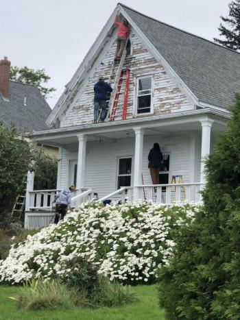 Rebuilding Together workers scrape and paint a house on Route 96, East Boothbay. Glenn Heisey photo