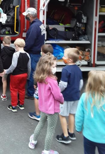 David McFarland helps students climb into a fire truck for a closer look. JANE CARPENTER/Boothbay Register