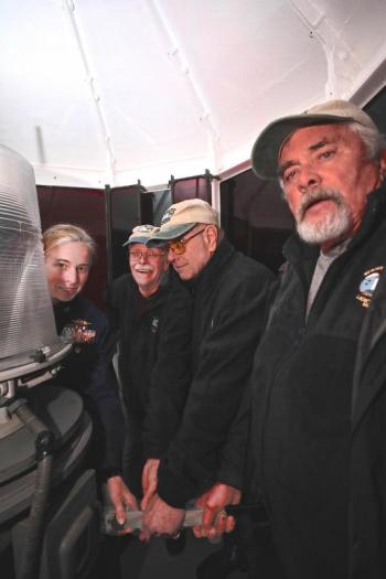 Hands on the lever, ready to relight Burnt Island’s tower on its 200th anniversary, Nov. 9, USCG Capt. Amy Florentino, Keepers Randy Griffing, Henry Sieg and Paul Kelly. Robert Mitchell photo