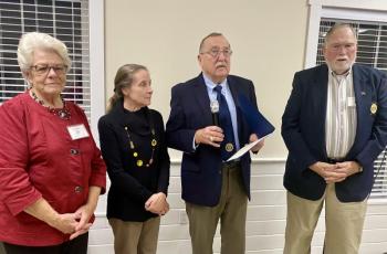 Ed Harmon, right, receives an award from David Patch as Sue Burge, left, and Mary Ellison of the Auxiliary watch. Jim Singer photo