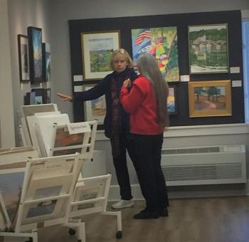Discussing a painting at Boohbay Region Art Foundation June 3. LISA KRISTOFF/Boothbay Register