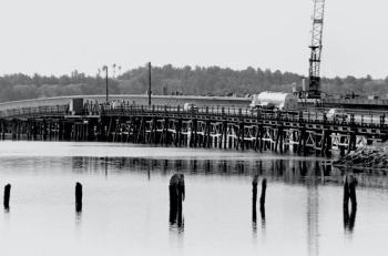 This never before published picture shows the former timber pile bridge alongside the new Davey Bridge a few weeks before the project was completed. Note the cross-bracing that had been placed on the old bridge’s pilings to strengthen them. PHIL DI VECE/photo
