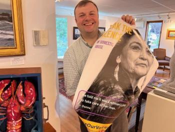 Andrew Gleason of Gleason Fine Art accepts a new FOV poster. Gleason’s is one of the businesses in town that never removed the original poster two years ago. Patrisha McLean photo