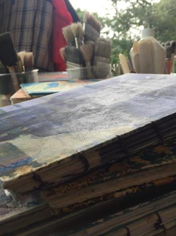 A few of the 25 journals Susan Newbold used for “Reveries: Journaling in Place.” LISA KRISTOFF/Boothbay Register