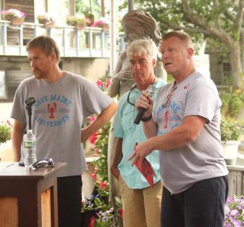Troy Plummer, left, and Mark Jones, center, of the Maine Lobstermen’s Association listen to Kevin Kelley of the MLA.. STEVE EDWARDS/Boothbay Register