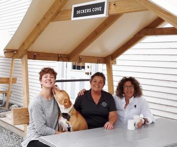 From left, Emma Gay, gift barn manager, Nancy Long, store manager and Barbara Leland, owner, Southport General Store, assisted by Olive. JANE CARPENTER/Boothbay Register