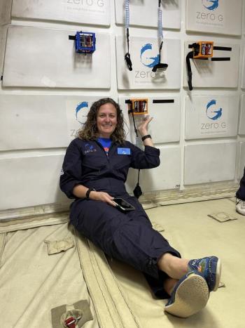Karin Iuzzolino-Paquin sits beneath research CubeSats on board Zero Gravity Corporation’s G-FORCE ONE. Courtesy photo