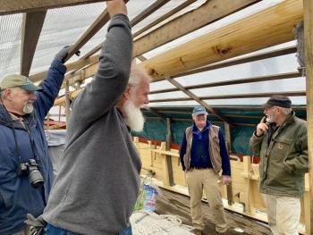 From left, some of the volunteers of Maine’s First Ship and the Virginia, Brunswick’s Paul Cunningham, Topsham’s Jim Amundsen and Brunswick’s Paul King talk with a longtime donor, Alna’s Fred Bowers, far right, when he stopped by the ship Jan. 18 in Wiscasset where it is wintering. SUSAN JOHNS/Wiscasset Newspaper
