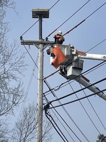 A Central Maine Power crewman finishes putting the osprey nesting box on the West Boothbay Harbor utility pole. Courtesy of Ted Varipatis/Serra Public Affairs