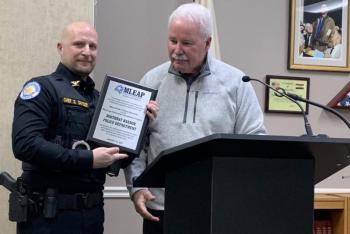 Maine Chiefs of Police Association Executive Director Ed Tolan presents Boothbay Harbor Police Chief Doug Snyder March 13 with a plaque commemorating the department achieving Maine Law Enforcement Accreditation Program certification. BILL PEARSON/Boothbay Register