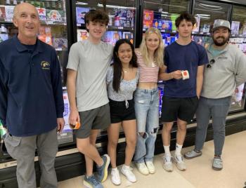 Boothbay Region High School students placed warning labels on alcoholic beverages May 11 in local stores to warn adults about laws pertaining to underage drinking. Pictured, from left, are Boothbay Harbor police officer Larry Brown, students Colby Allen, Ariel Alamo, Kate Campbell and Gryffin Kristan and Boothbay Region YMCA Youth and Teen Director Rudi Bottse. BILL PEARSON/Boothbay Register