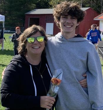 Boothbay/Wiscasset runner Ryan Clark presented his mother, Sarah Clark, with a flower May 9 during the Senior Night ceremony prior to the final Mountain Valley Conference home meet. BILL PEARSON/Boothbay Register